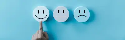 Una mano che indica tre facce bianche rotonde con semplici espressioni sorridenti, neutre e accigliate su uno sfondo blu